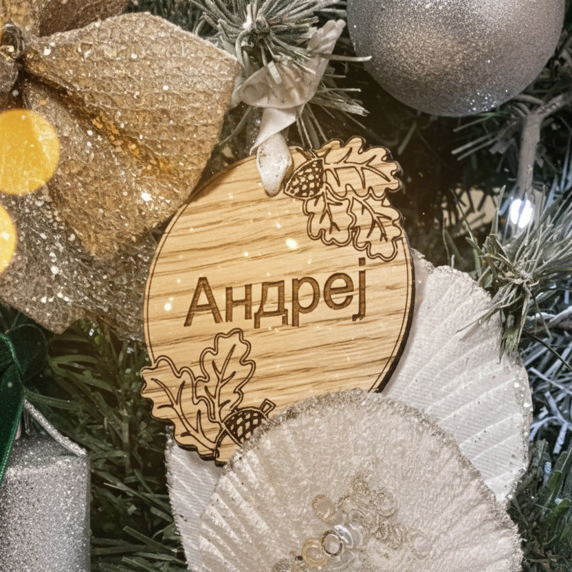 Wooden ornament with engraved name 'Andrej' on a Christmas tree.
