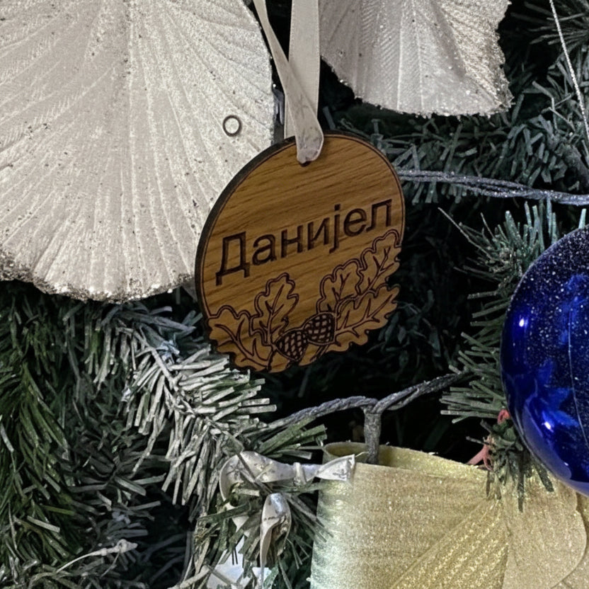Wooden ornament with engraved name on a Christmas tree